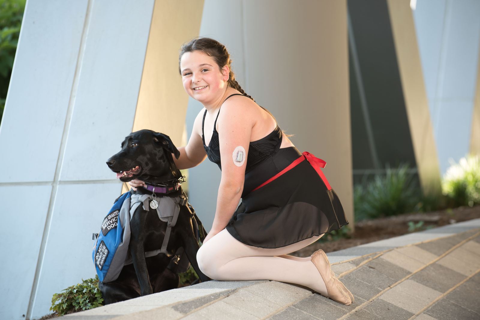 Girl in ballet warmup outfit poses with dog
