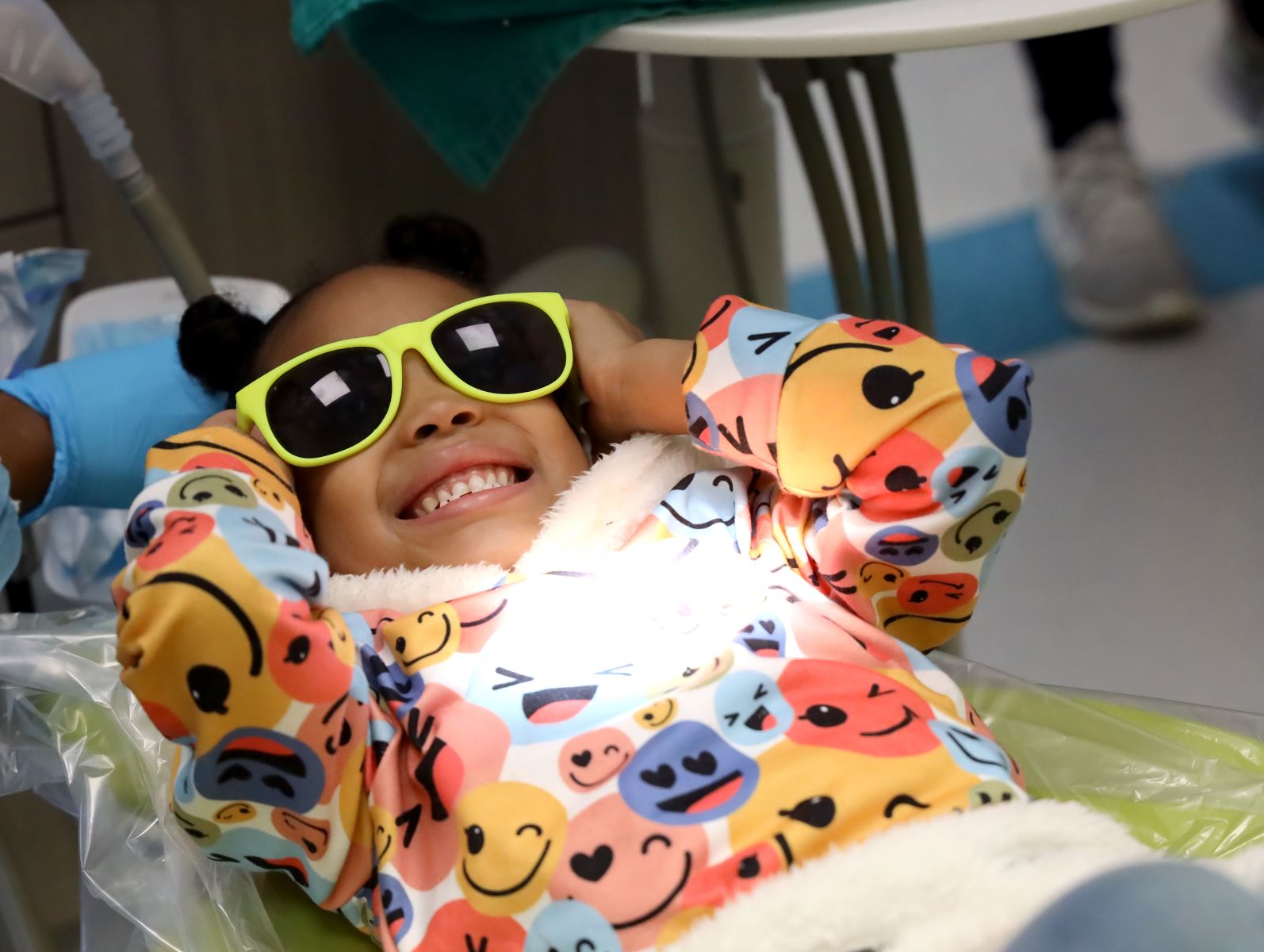 Young girl smiling with sunglasses on at the VCU Dental Care Pediatric Clinic