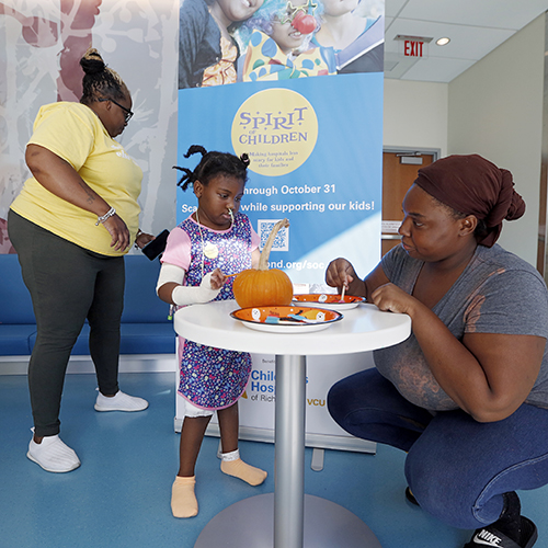 CHoR patient Trinity painting a pumpkin with her mom and nana