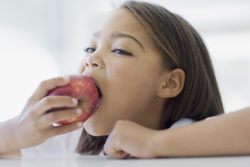 girl eating apple as part of healthy diet for kidneys
