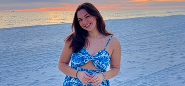 Addison, wearing a blue patterned bathing suit on a beach