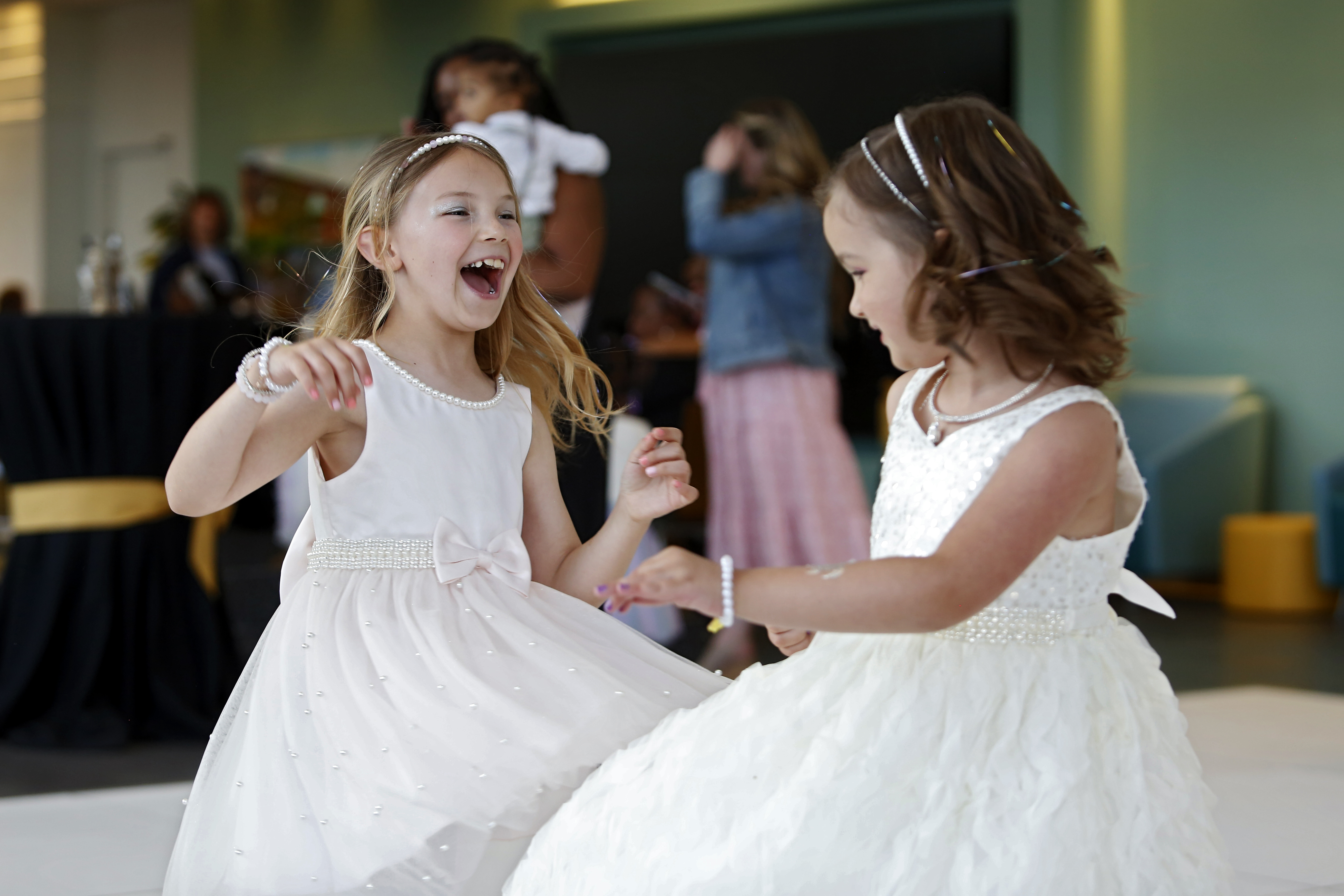 2 girls in white dresses dance