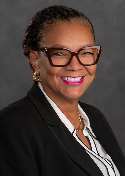Headshot of Debora Sadm-smith wearing glasses and smiling