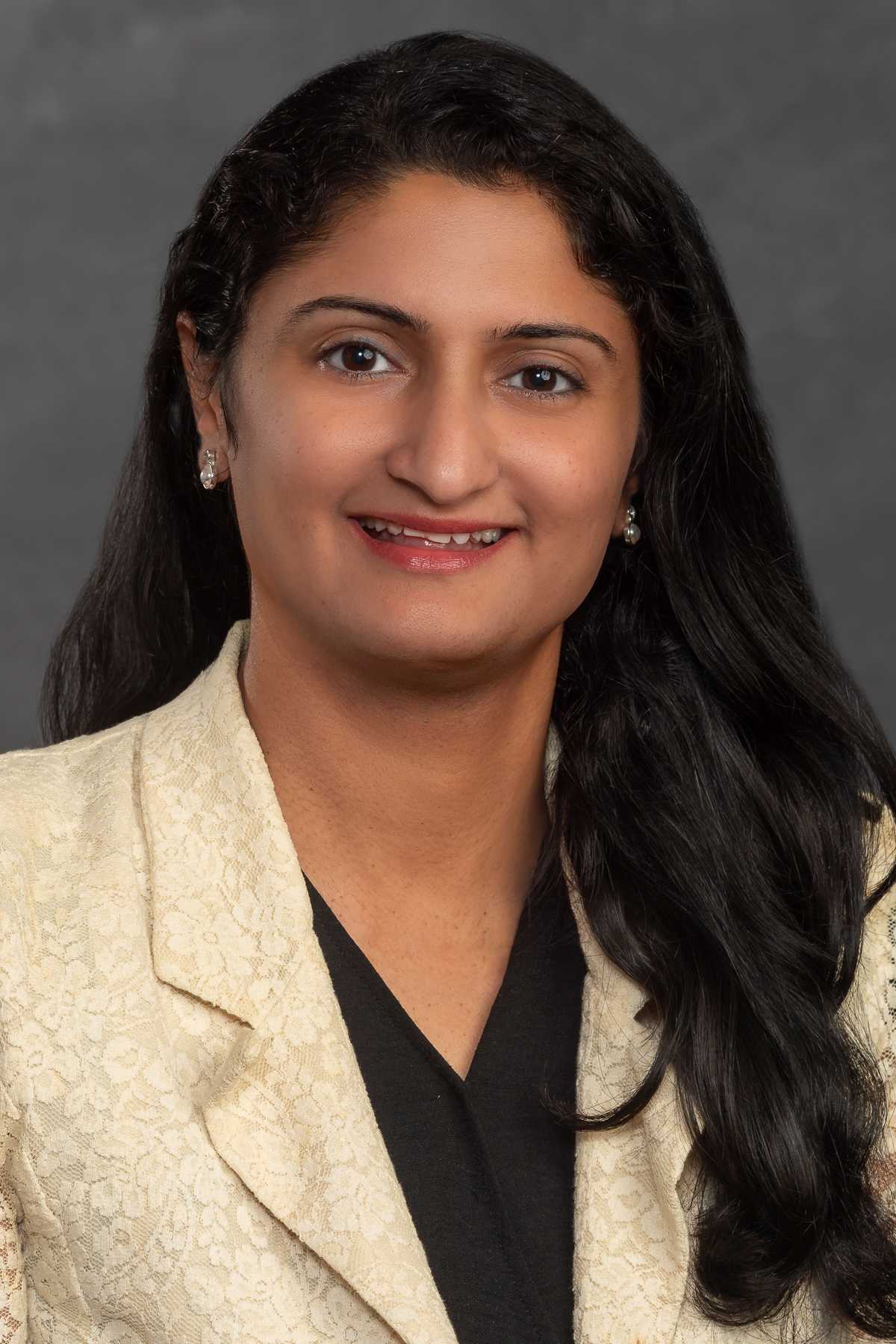 Jinkal Shah, wearing a beige suit over a black blouse